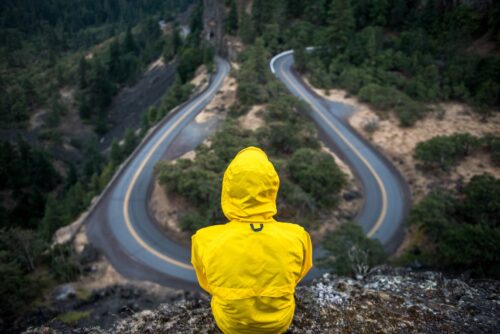 A person in yellow coat looking over a road