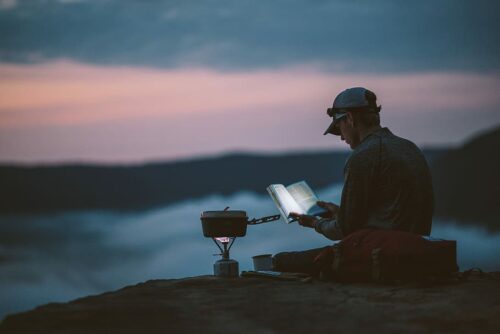 A person reading a book in the dark