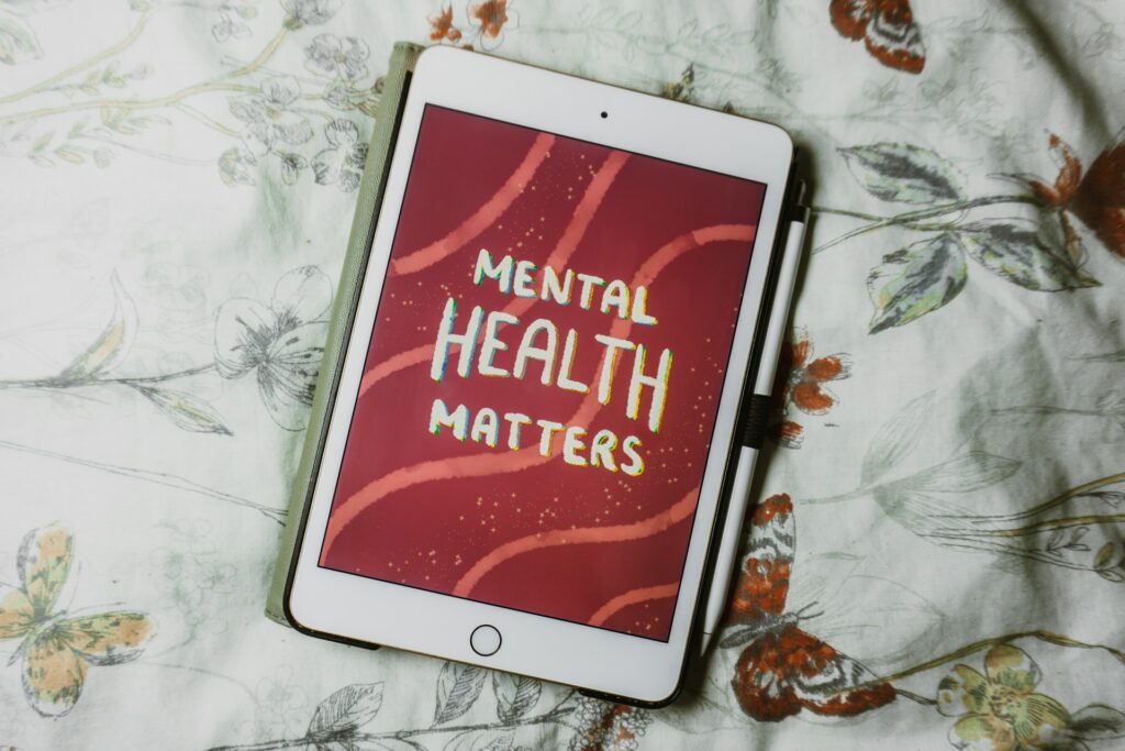 This image image shows a tablet on a floral background displaying "MENTAL HEALTH MATTERS" in a festive design, symbolizing the importance of well-being.