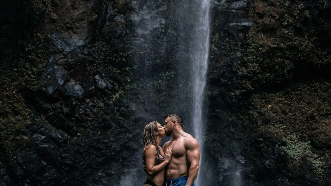 a couple kissing under a waterfall